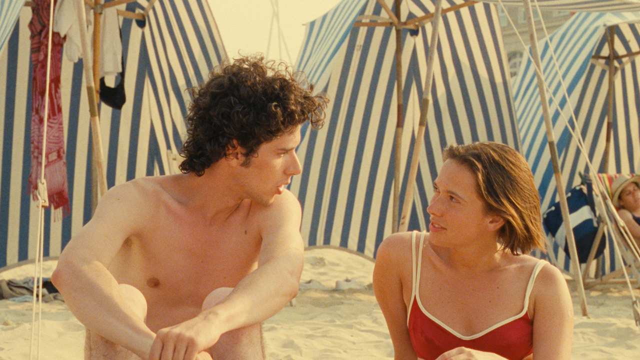 a man and woman sitting on the beach